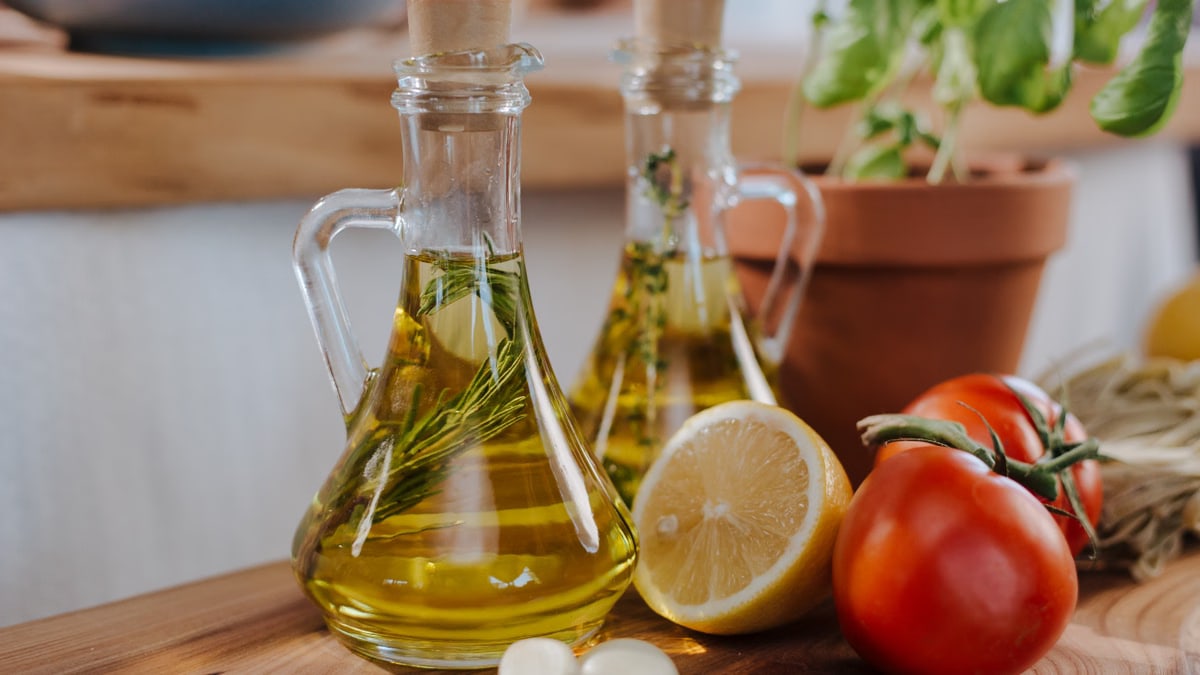 Close-up of fresh ingredients for Italian cooking featuring olive oil and basil.